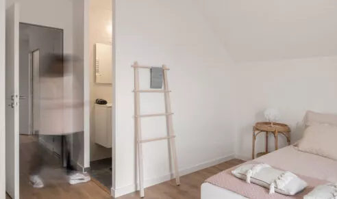 Maisons Patio à Carnac, maison témoin aménagé, photo de la chambre double avec salle d'eau. Effet de mouvement d'une personne allant prendre sa douche.