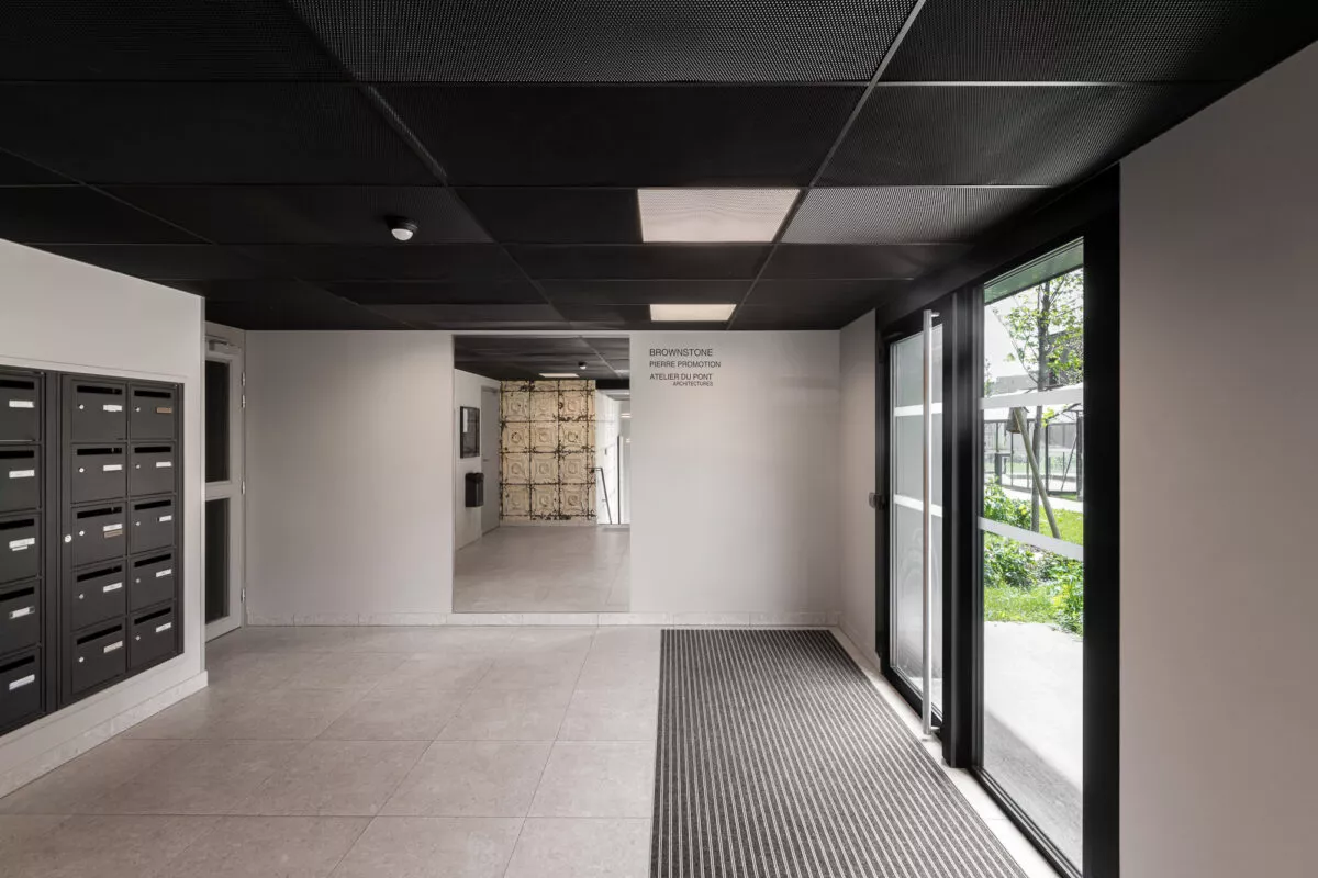 L'entrée intérieur de la résidence Brownstone située à Saint-Jacques-de-la-Lande, près de Rennes. Des logements neufs réalisés par Pierre Promotion.