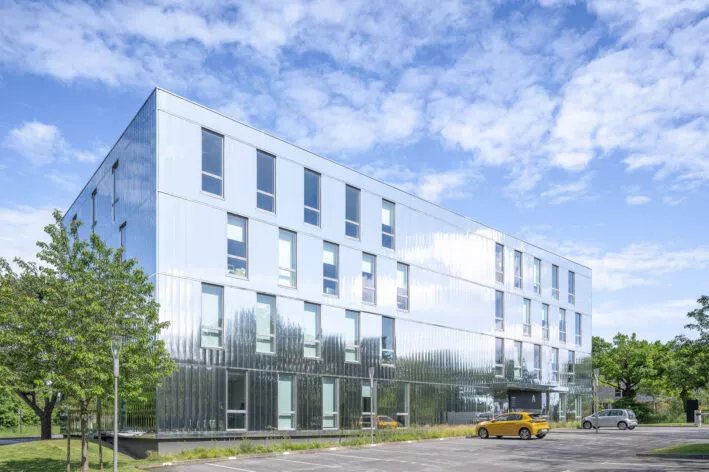 Façade extérieure et parking du programme tertiaire Les Reflets situé à Saint-Herblain, près de Nantes. Un ensemble d'immobilier neuf réalisé par Pierre Promotion.