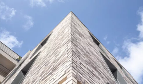 Bâtiment en terres Terra situé à Liffré proche de Rennes avec un beau ciel bleu breton