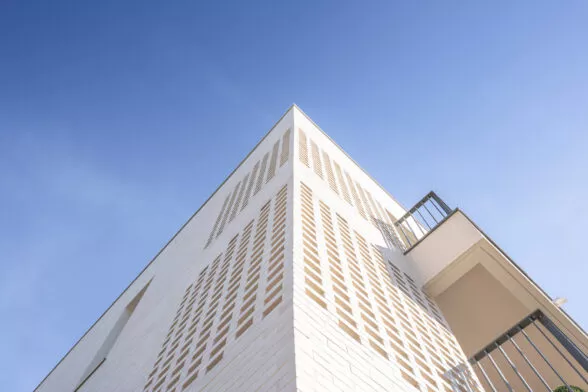 Façade extérieure avec un grand ciel bleu de la résidence Villa Blanche à Montauban-de-Bretagne, près de Rennes. Des logements neufs réalisés par Pierre Promotion.