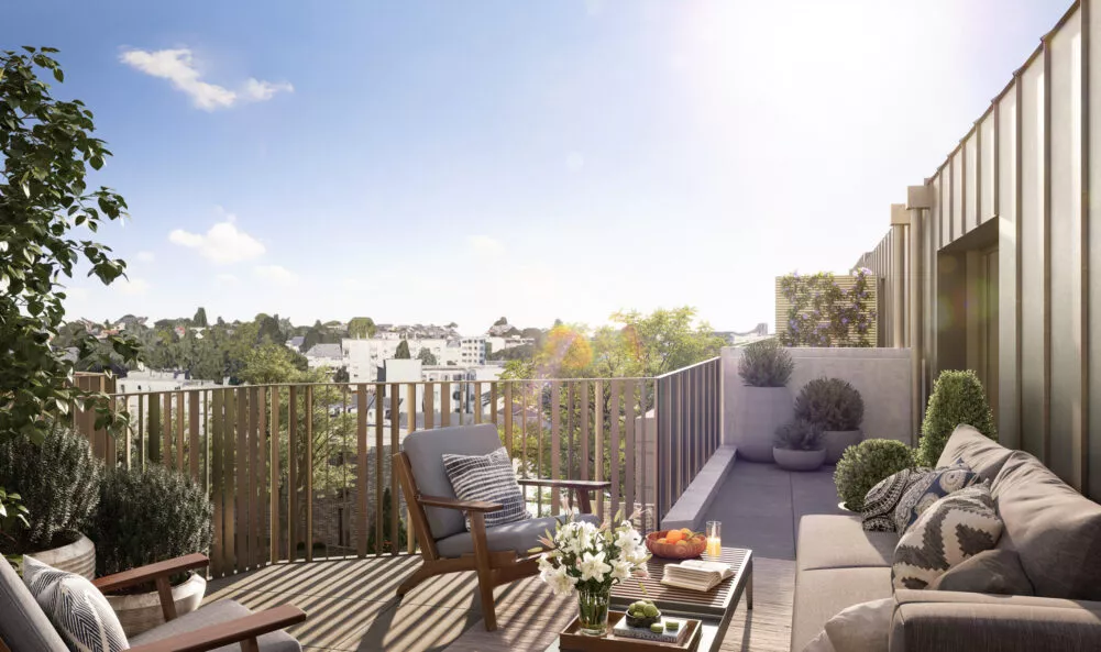 Une terrasse d'un immeuble en plein soleil où est présenté un salon de jardin.
