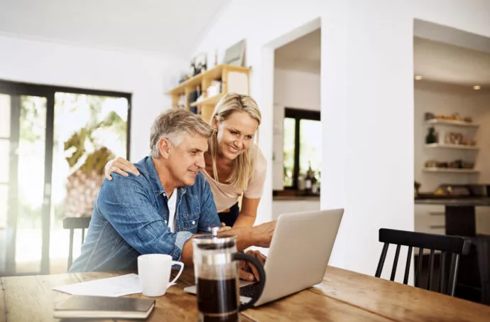 Un couple regardant les offres d'immobilier neuf sur leur ordinateur, sur le site internet Pierre Promotion.