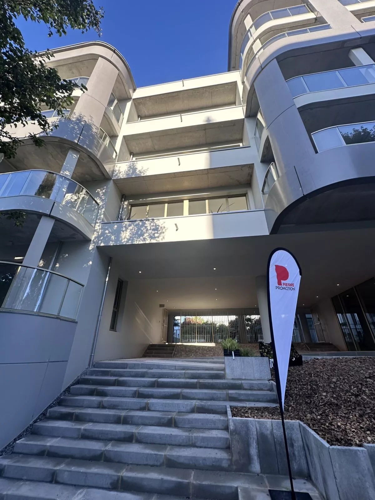 Entrée de la résidence Esprit du Large à Brest pendant la semaine de livraison des appartements aux résidents. Une flamme Pierre Promotion devant pour accueillir les nouveaux acquéreurs.