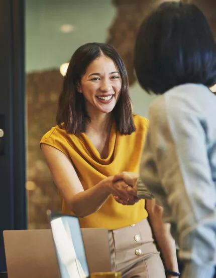 Deux femmes se serrant la main après avoir eu un entretien professionnel dans la promotion immobilière.
