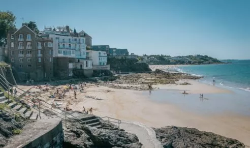 La plage de Saint Enogat à Dinard où se baignent touriste et résidents sous un beau ciel bleu.