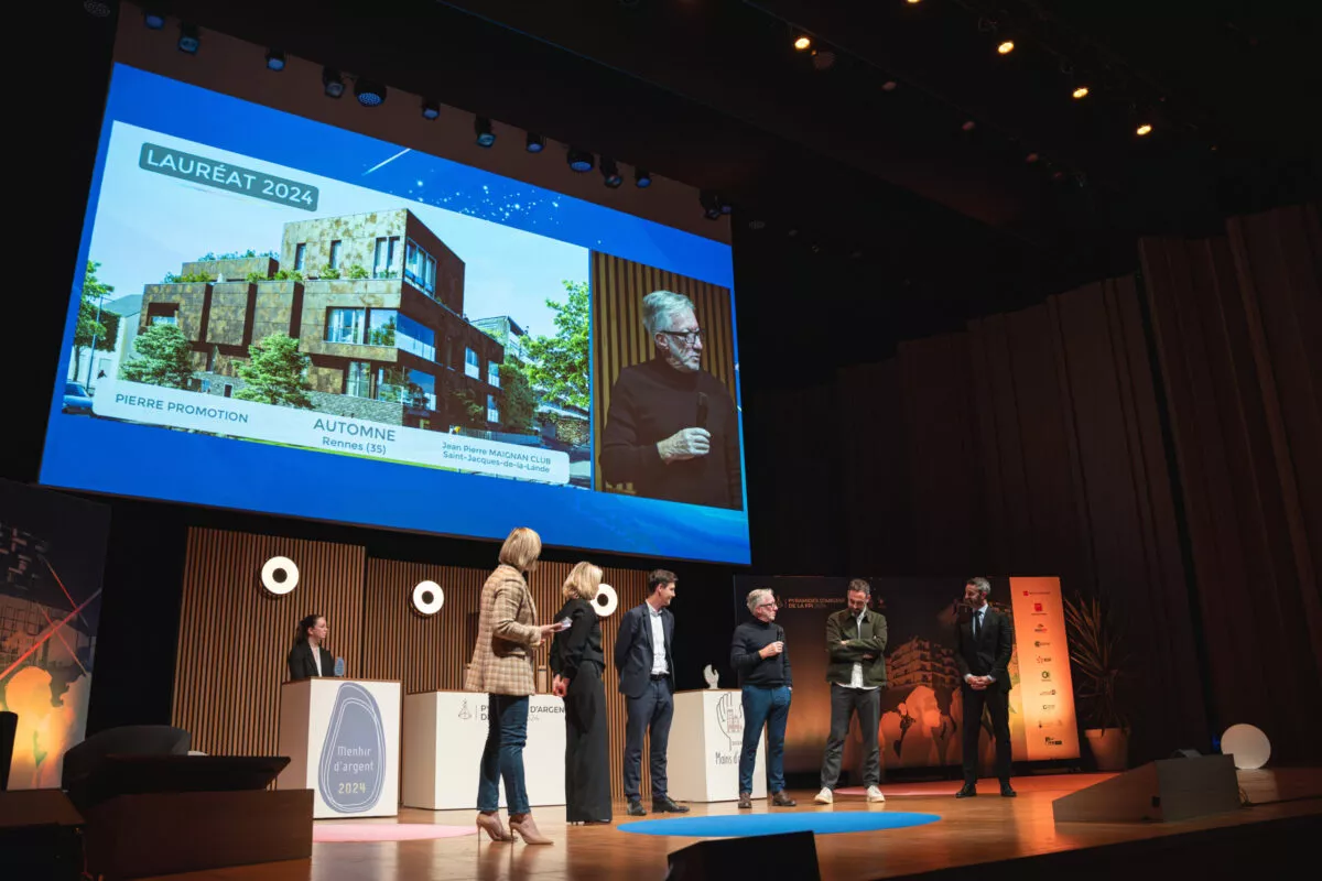 Conférence avec plusieurs intervenants sur scène et projection d’une présentation en arrière-plan