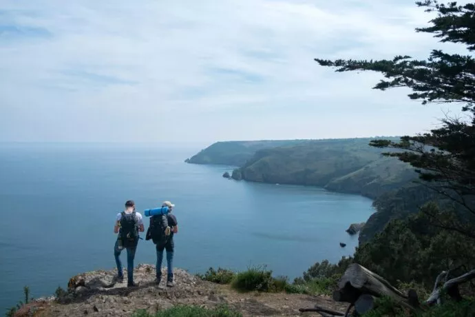 Presqu'ïle de Crozon, en Bretagne. Deux touristes en haut d'une colline en train de regarder la mer.