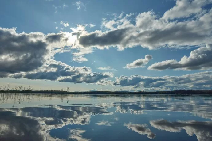 Etendue d'eau avec un ciel bleu parsemé de nuage.