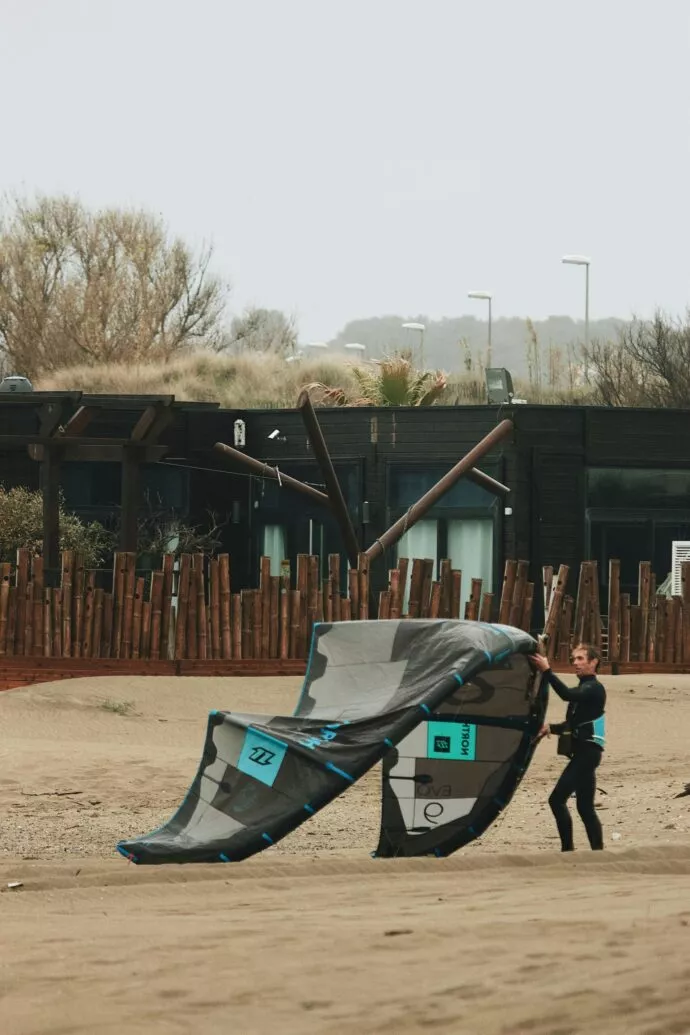 Kitesurfeur installant son aile sur une plage bretonne ventee
