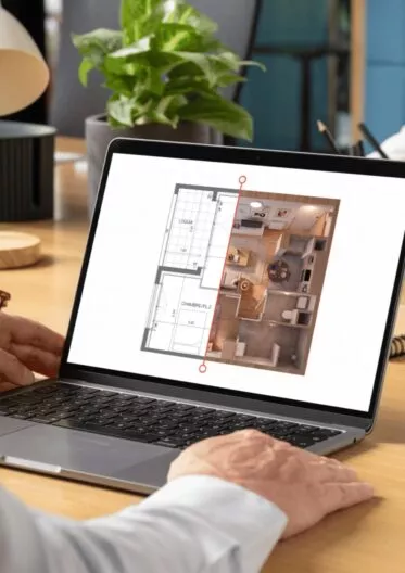 Homme en train de regarder l'appartement qu'il vient d'acheter en VEFA sur son ordinateur
